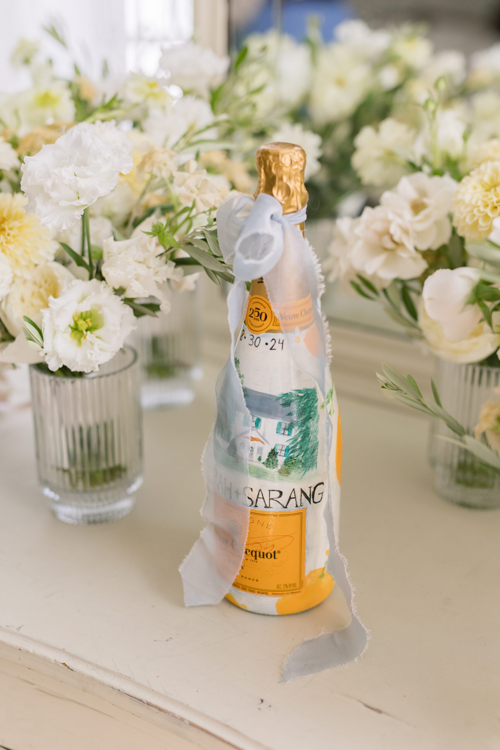Custom Veuve Clicquot bottle at elegant Destination Wedding in Italy, adorned with ribbon and florals.