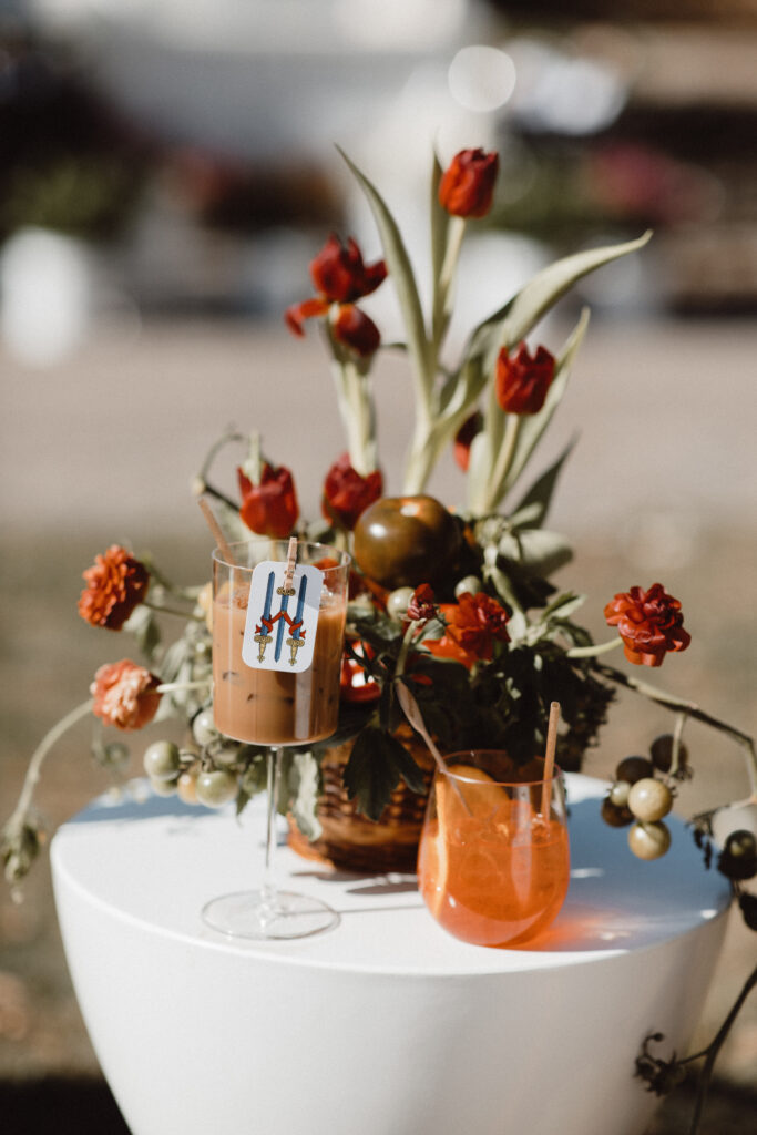 Autumnal cocktail display with deep red florals and iced drinks for fall weddings in New England.