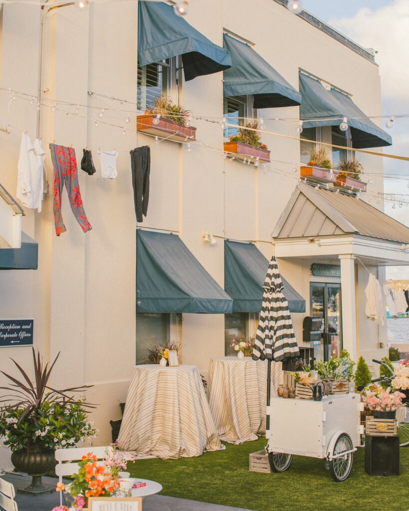 Charming coastal storefront styled with florals and linens, perfect for Italian Garden Weddings by the sea.