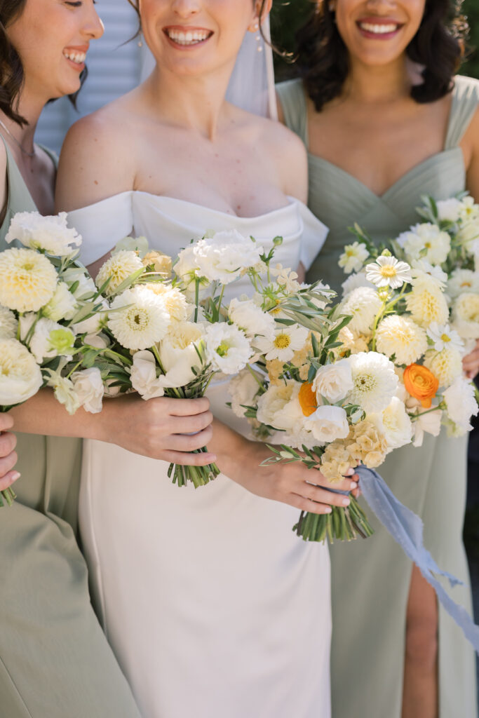 Bride and bridesmaids holding white and yellow floral bouquets, celebrating the best time of year to get married.