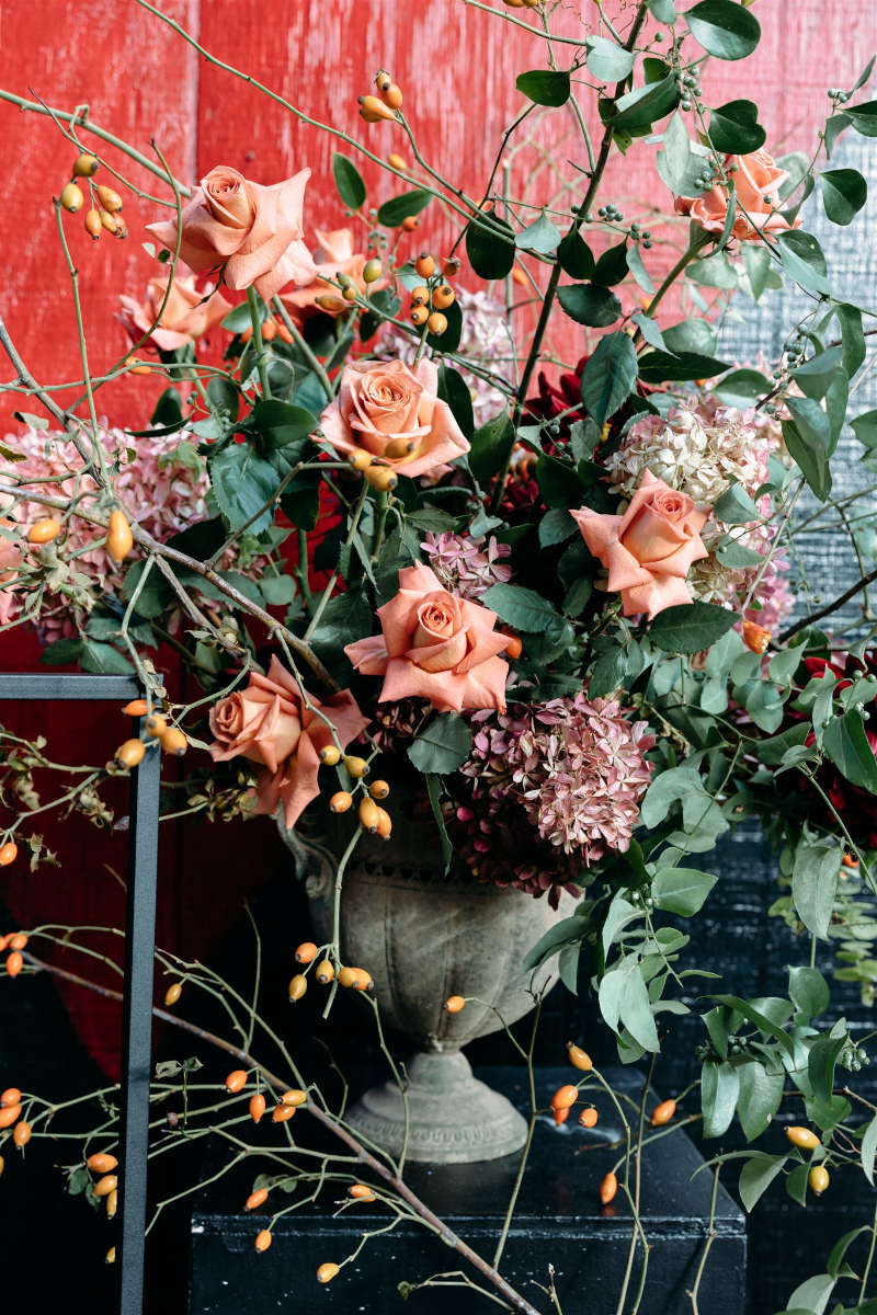 Modern wedding cake with sculptural florals and fruit styling, aligning with 2026 wedding design trends.