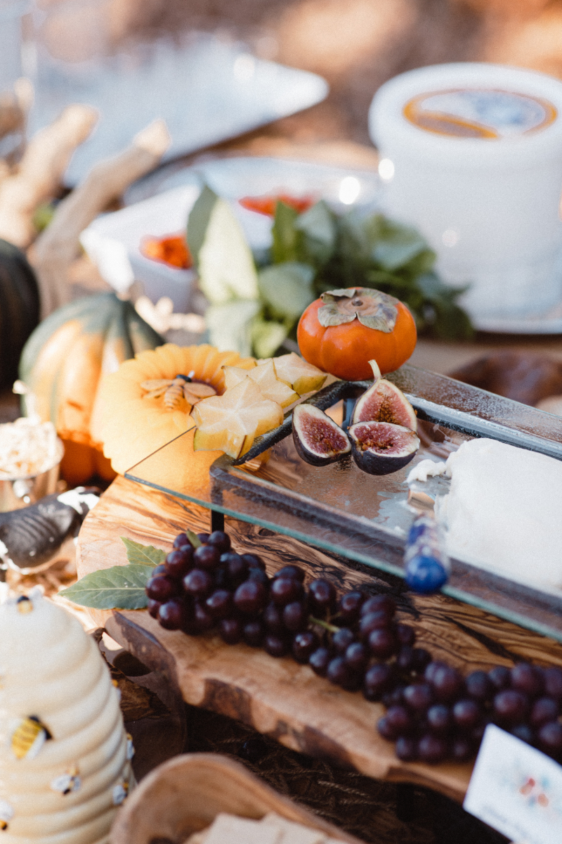 Colorful grazing table with fresh fruit, cheeses, and seasonal decor styled for a wedding.