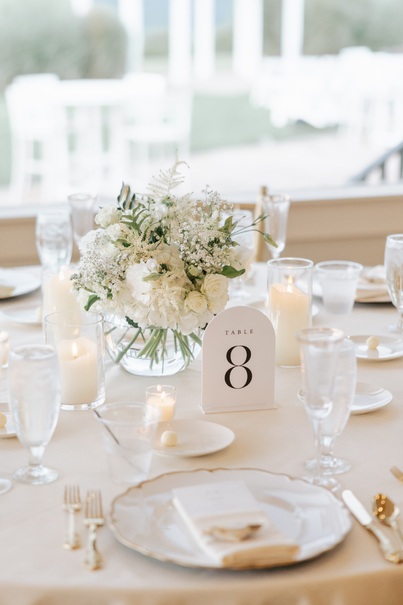Close-up of an elegant table setting with white florals and candles at one of the best intimate wedding venues.