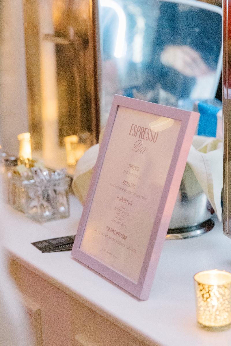 Framed espresso bar menu displayed with candles and soft lighting