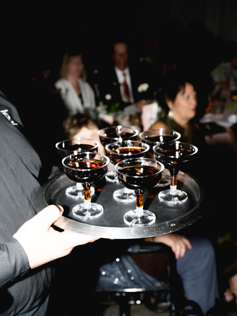 Espresso martinis served on tray during lively evening reception.