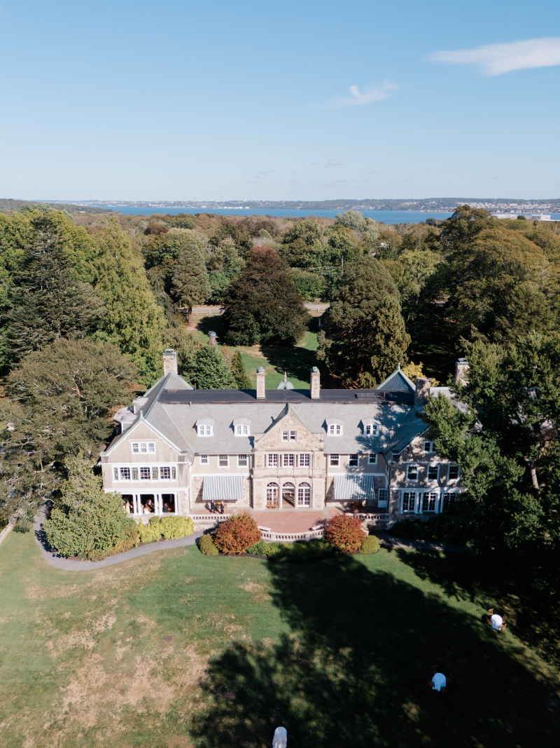 Aerial view of Blithewold Mansion wedding overlooking gardens and waterfront in Bristol, Rhode Island.