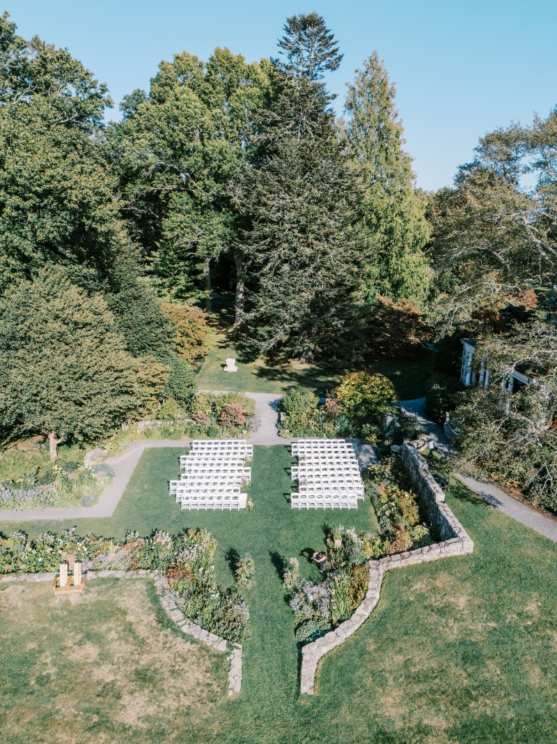 Aerial view of garden ceremony setup with white chairs and manicured lawns.