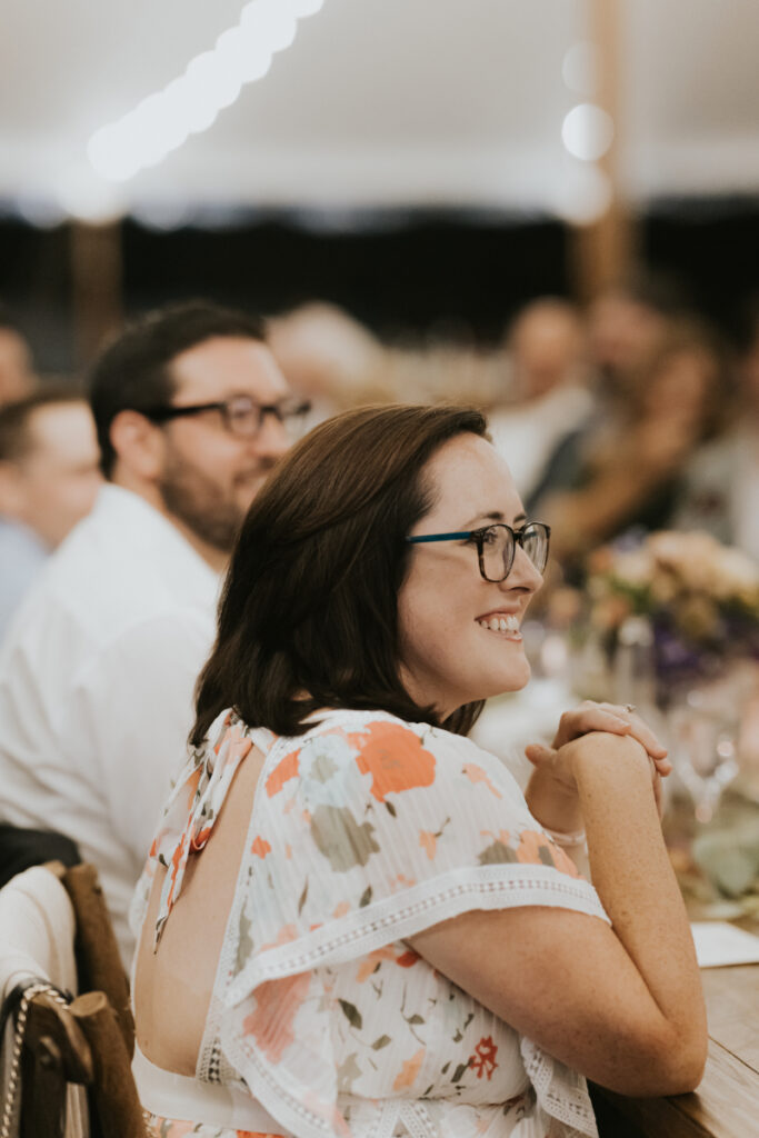 Guest smiling during a wedding dinner celebration.