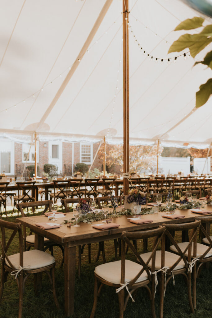 Tented reception setup with long tables at Italian countryside wedding.