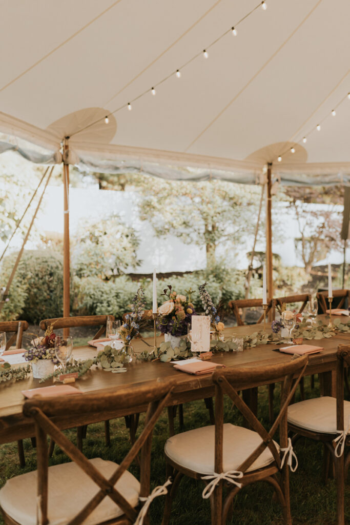 Outdoor tent interior with floral tablescapes at Italian countryside wedding.