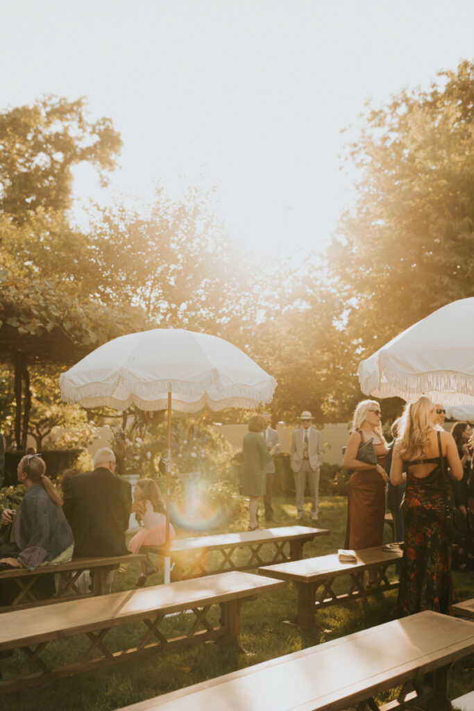 Guests seated under umbrellas at sunset 