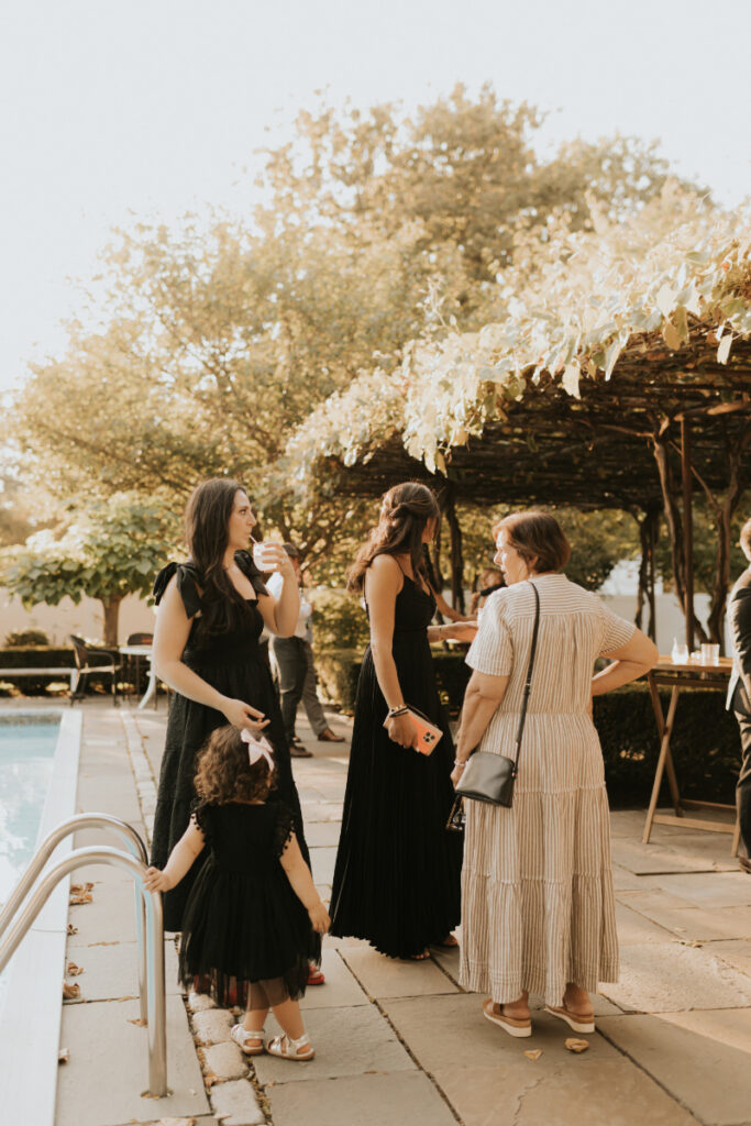 Guests mingling by pool during Italian countryside wedding cocktail hour.