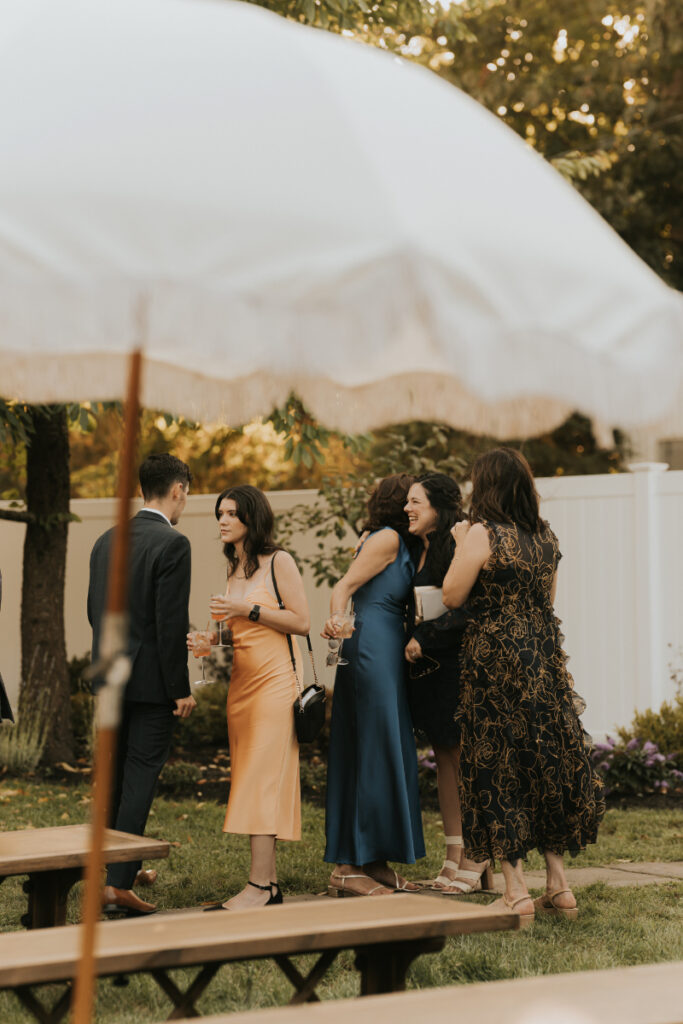 Guests chatting during Italian countryside wedding cocktail hour outdoors.