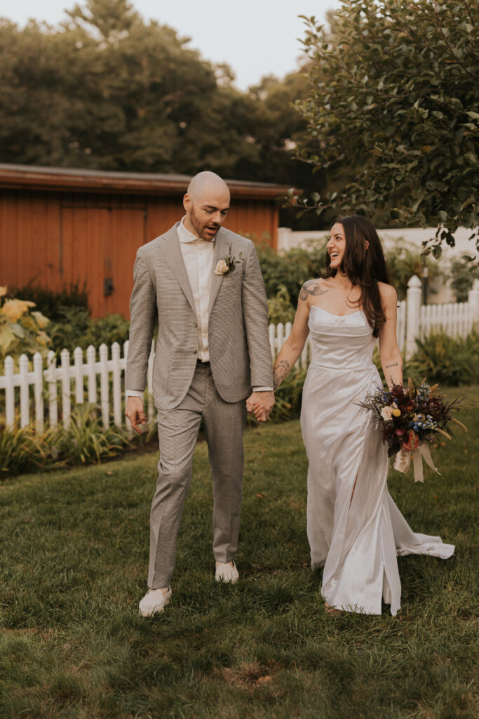 Bride and groom walking hand in hand during Italian countryside wedding at family home.