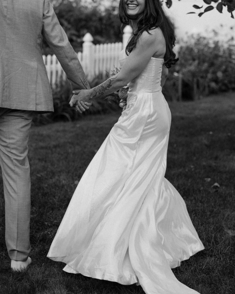 Bride and groom holding hands in a black and white photo