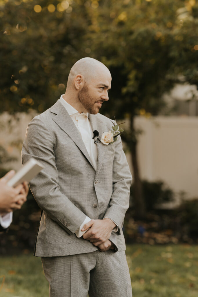 Groom waiting during Italian countryside wedding ceremony at private family estate.