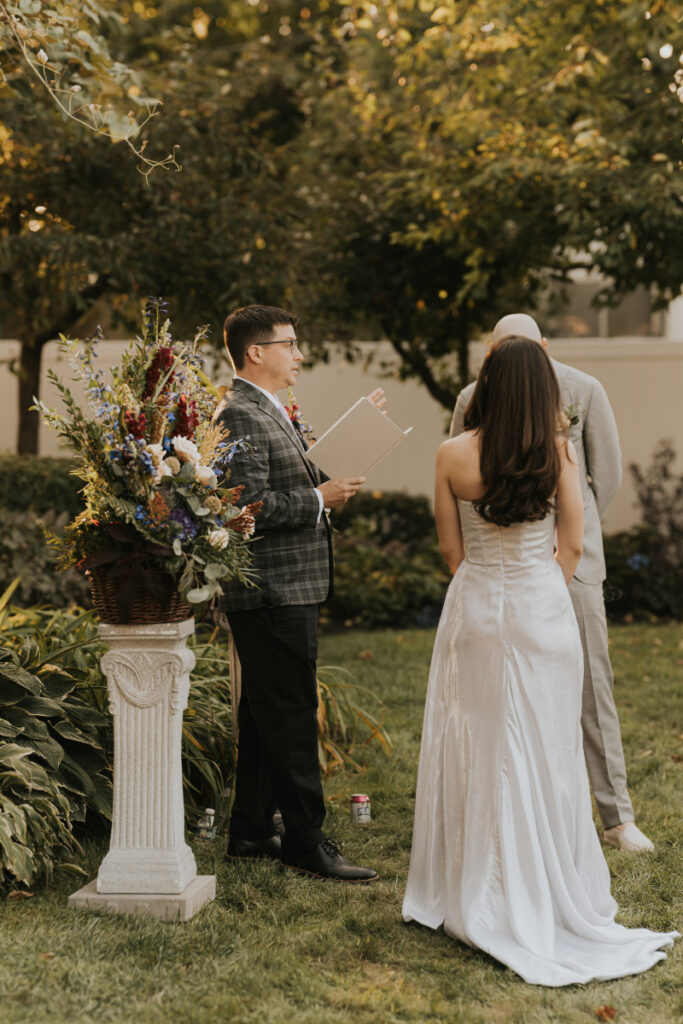 Bride and groom facing officiant during Italian countryside wedding at family estate.