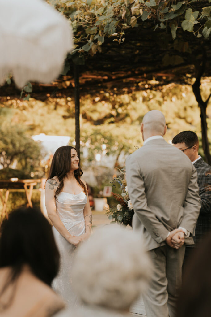 Guests seated with children during Italian countryside wedding ceremony outdoors.