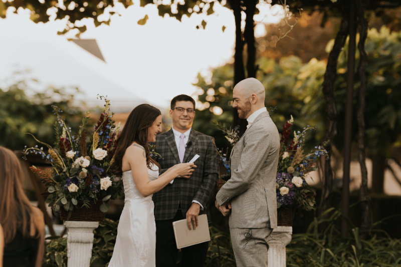Bride reading vows to groom during Italian countryside wedding ceremony.