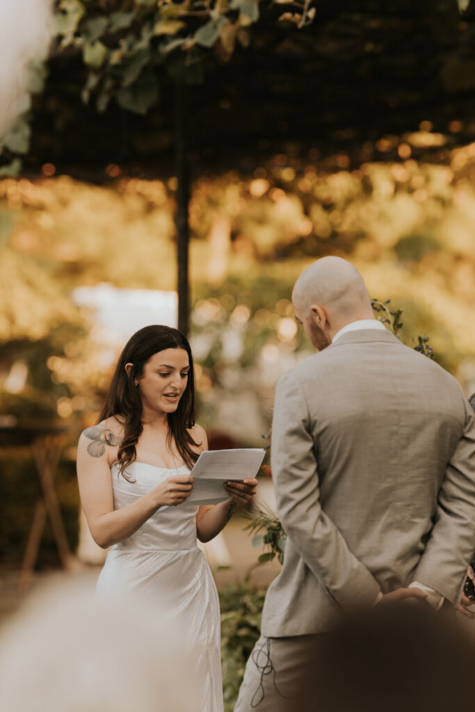 Bride reading vows during Italian countryside wedding ceremony at family estate.
