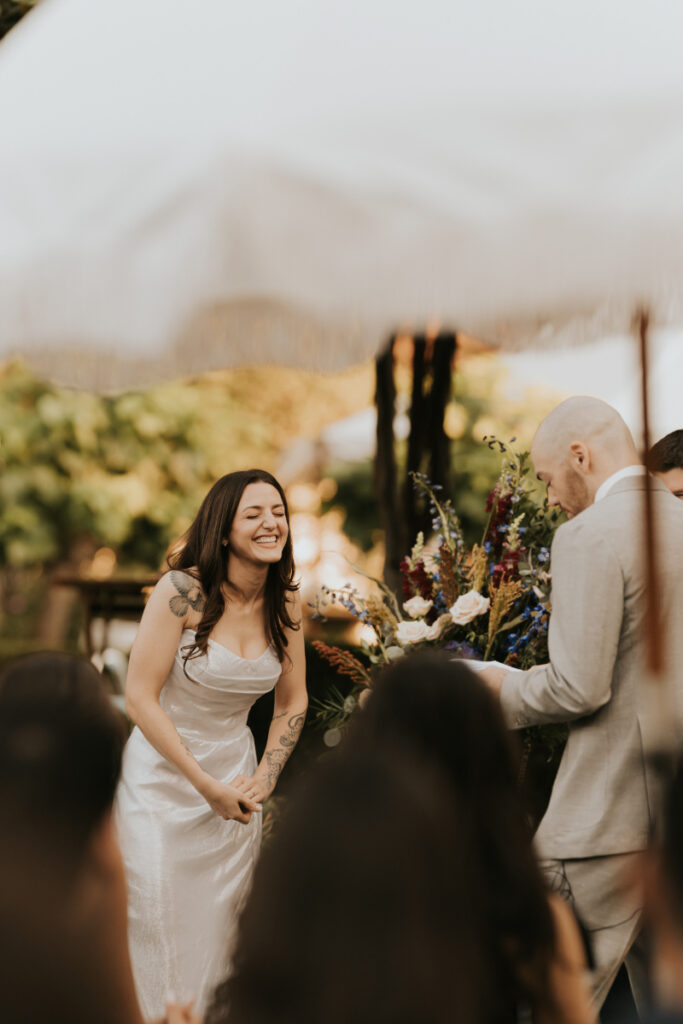 Bride laughing during Italian countryside wedding ceremony at family estate.