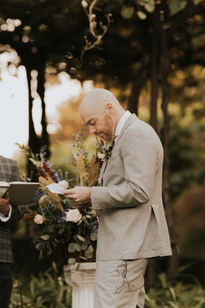 Bride smiling during Italian countryside wedding vows under garden trees.