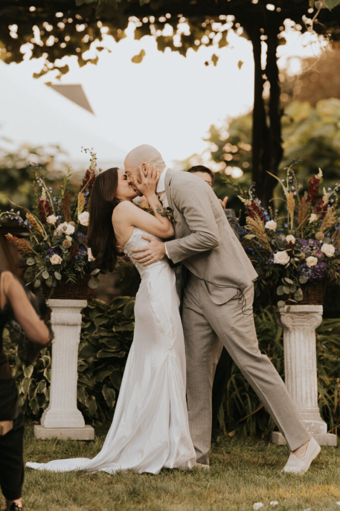 Bride and groom kissing at Italian countryside wedding ceremony.