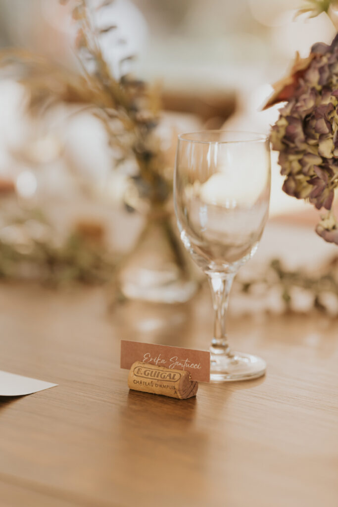 Place setting detail with cork escort card at Italian wedding.