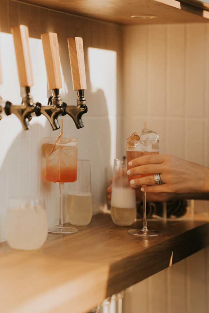 Bar setup with liquor bottles at Italian countryside wedding reception.