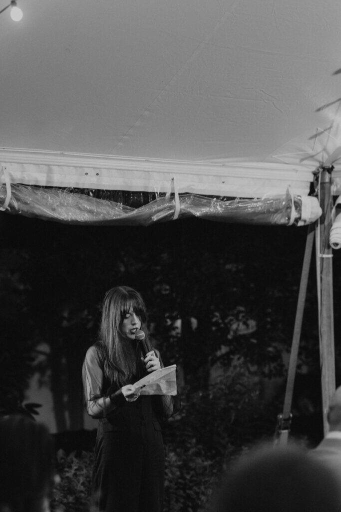Guest giving speech during Italian countryside wedding reception.