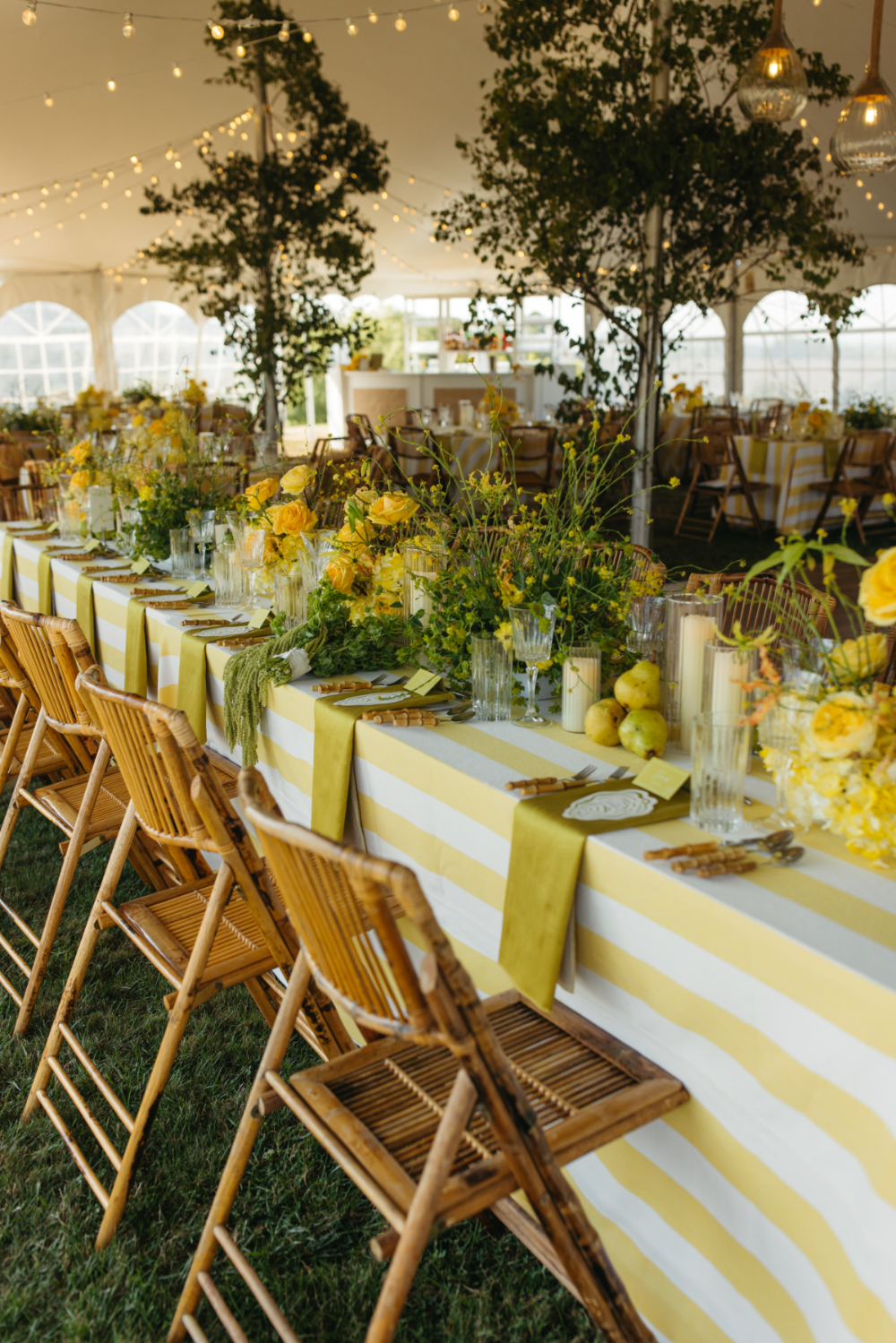 beautiful tablescape with a yellow striped wedding table linen at an outdoor tented wedding in Rhode Island