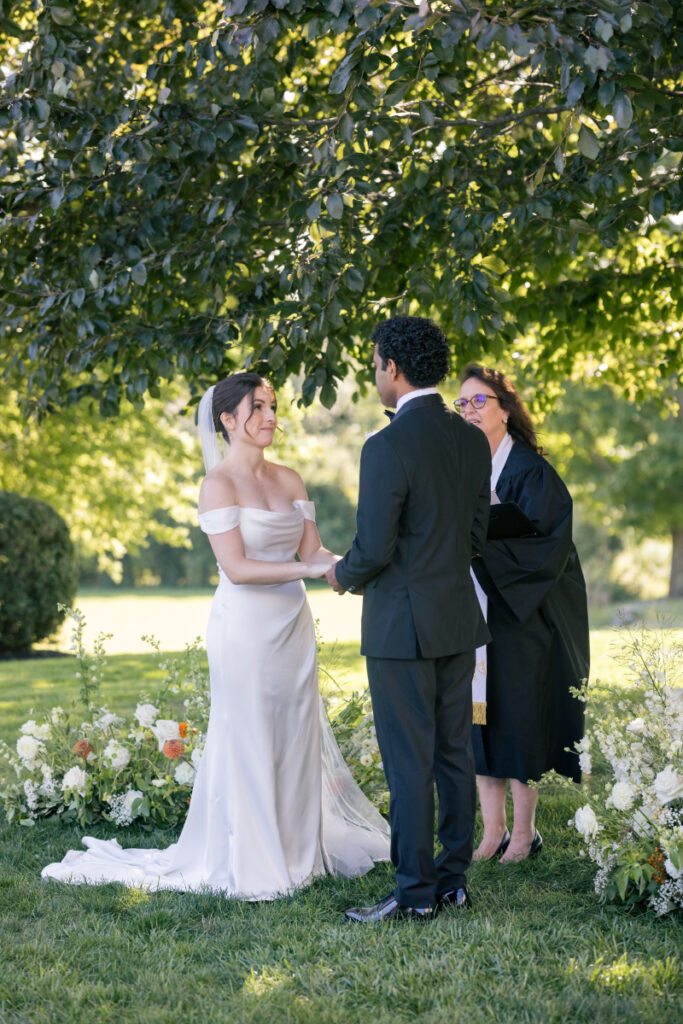 Bride and groom exchange vows during an outdoor garden ceremony at their wedding at Connemara House.