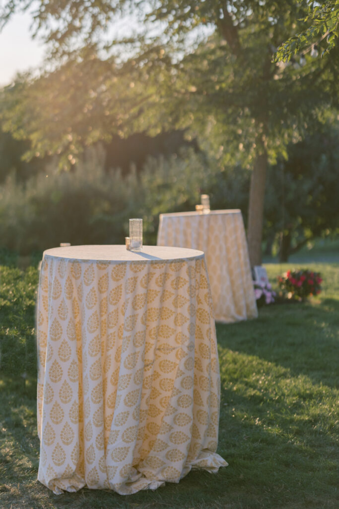 Outdoor cocktail tables with citrus-patterned linens at a garden wedding at Connemara House.