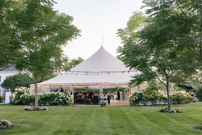 Elegant tented reception surrounded by greenery during a summer wedding at Connemara House.