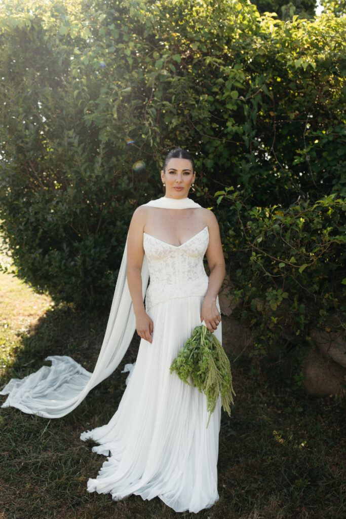 Bride laughing with bridesmaids in yellow and green dresses during joyful pre-ceremony portraits.