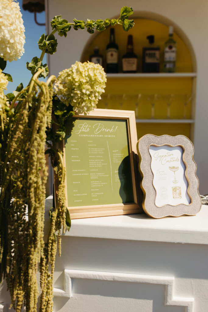 Close up of martini bar menu and floral arrangement on custom cocktail bar display.