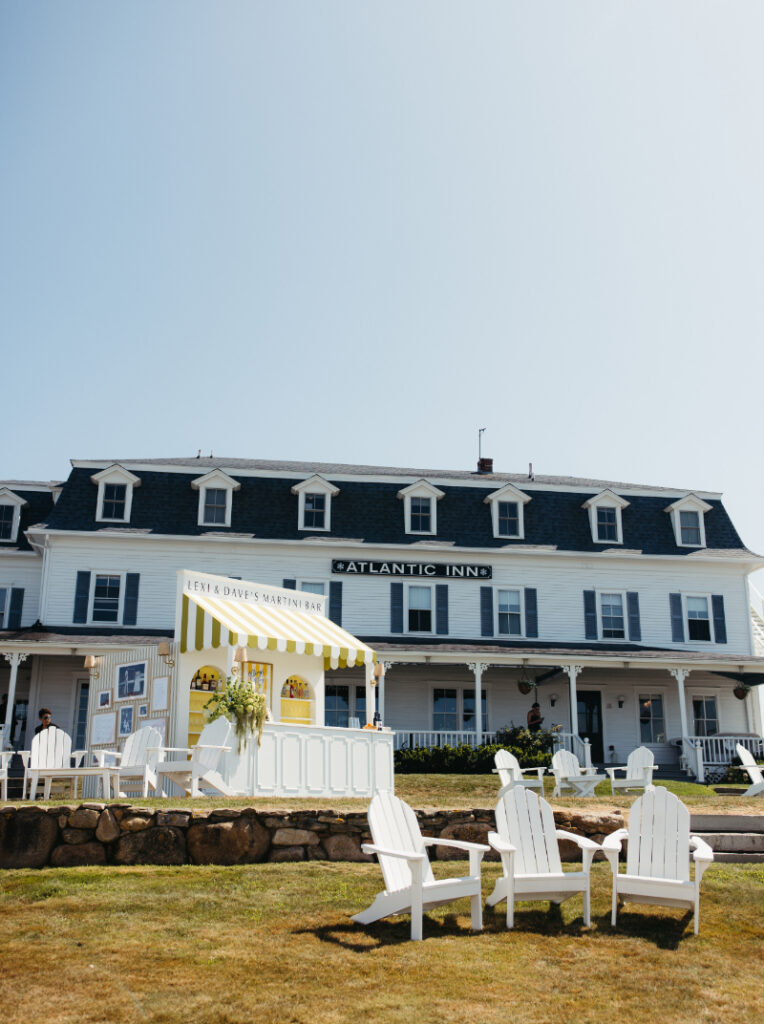 Outdoor lounge chairs and custom cocktail bar setup in front of historic coastal inn.