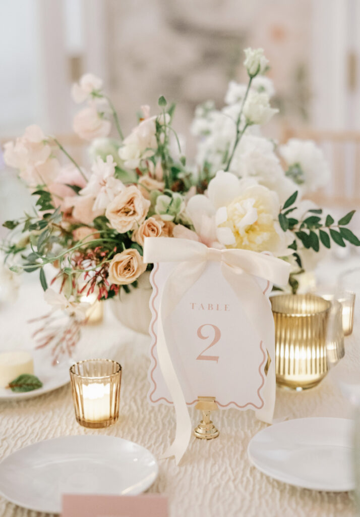 Table details that feel soft but styled—scalloped paper goods, layered florals, and a palette that reads intentional without trying too hard