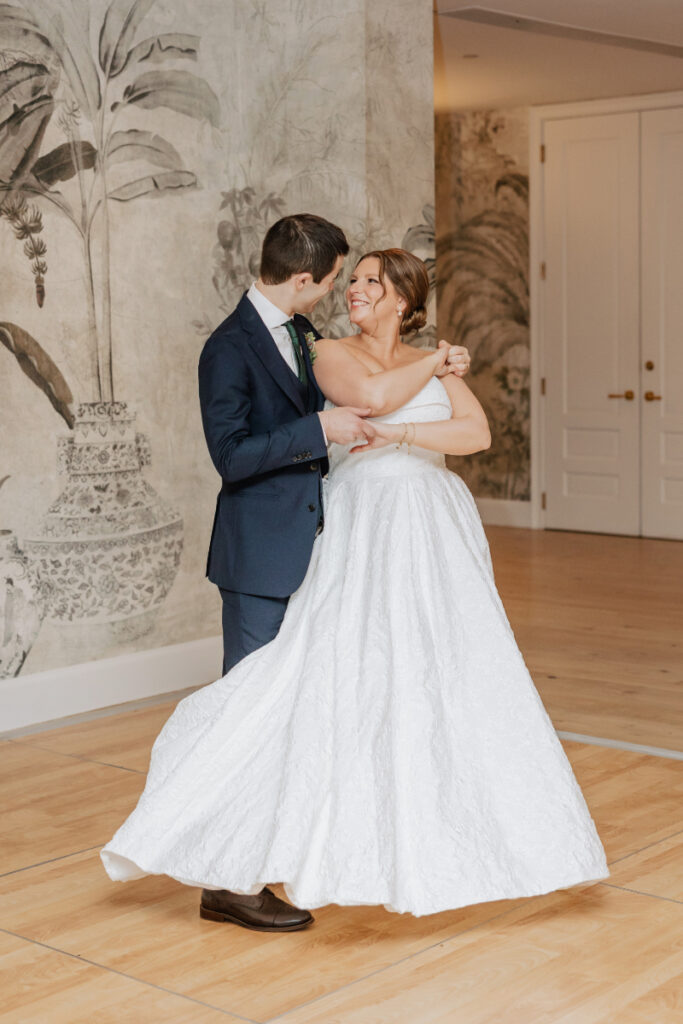 Couple embracing and spinning on the dance floor during their first dance