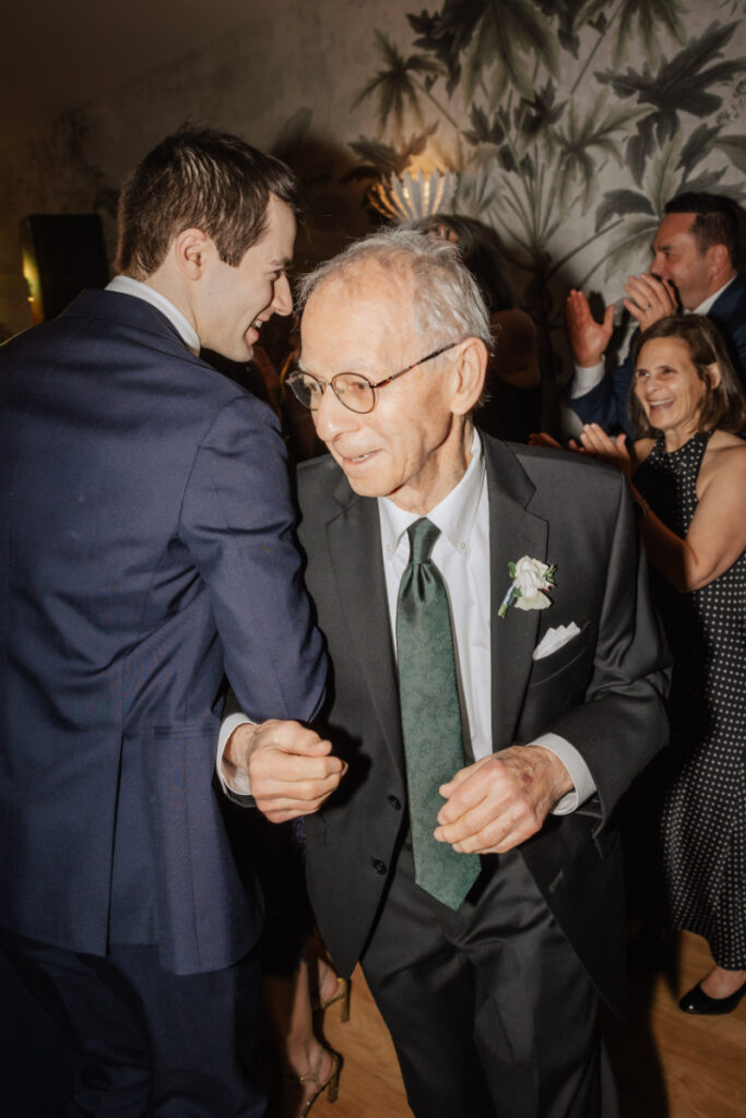 Bride and groom lifted on chairs during a lively dance floor tradition