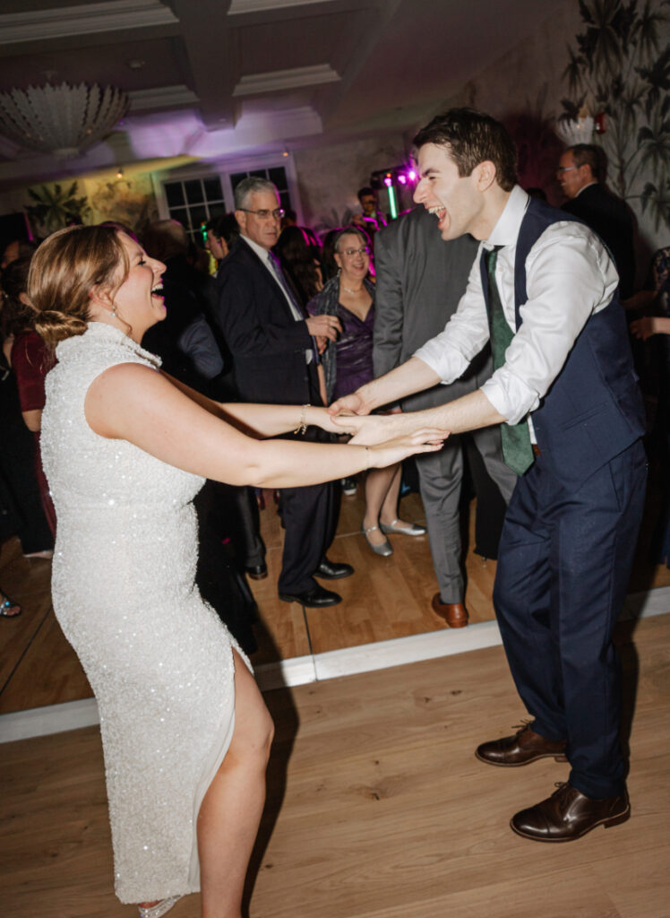 Couple dancing together on the dance floor, holding hands and smiling
