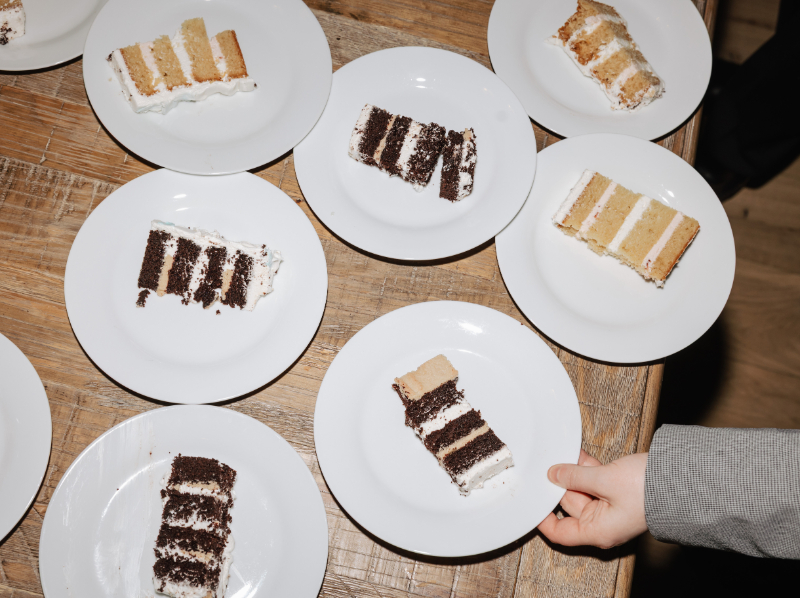 Slices of chocolate and vanilla cake plated on white dishes ready to be served
