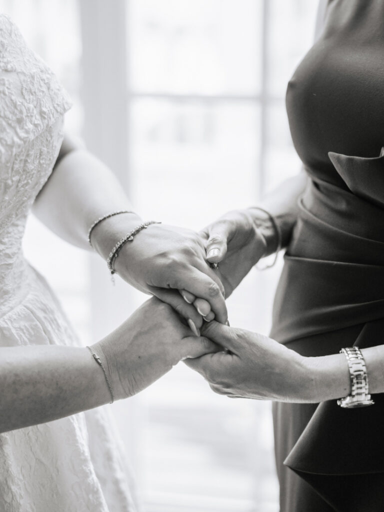 Bride holding hands with loved ones during getting ready, emotional moment captured by Newport wedding planner