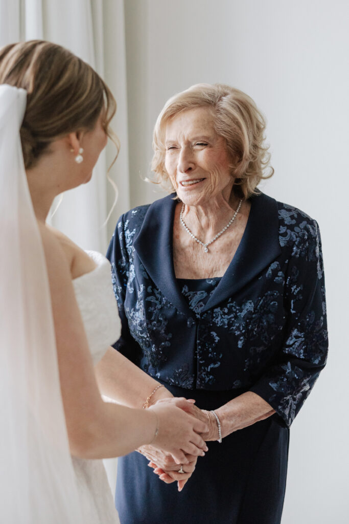 Bride holding hands with grandmother during getting ready, emotional family moment by Newport wedding planner