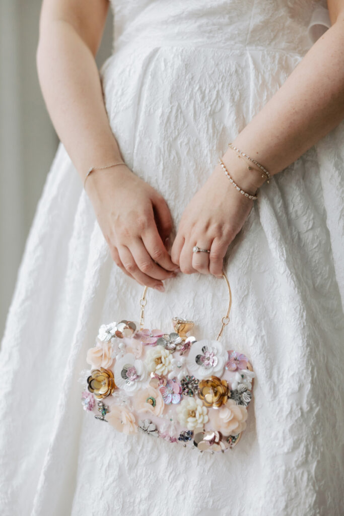 Bride holding floral handbag with textured gown, detailed Newport wedding bridal styling moment