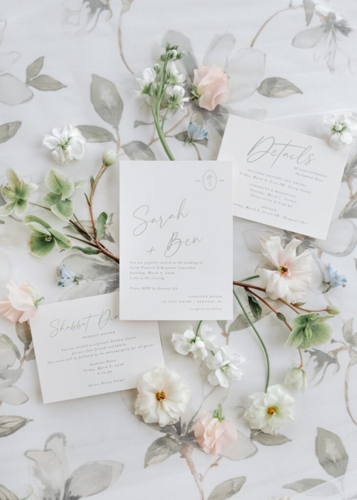 Soft floral wedding invitation suite with pastel blooms, styled flat lay by Newport wedding planner