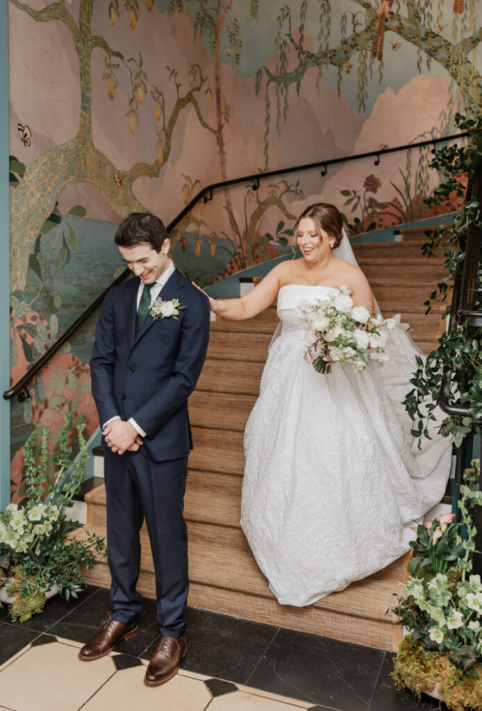 First look moment on staircase with mural walls, emotional reveal during Newport wedding day