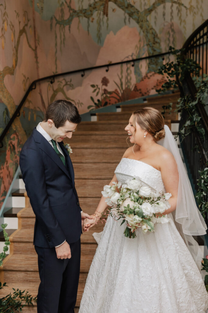 Couple holding hands and smiling after first look, intimate moment at Newport wedding venue