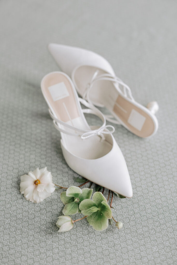 White bridal heels with delicate florals on textured linen, elegant Newport wedding planner detail styling