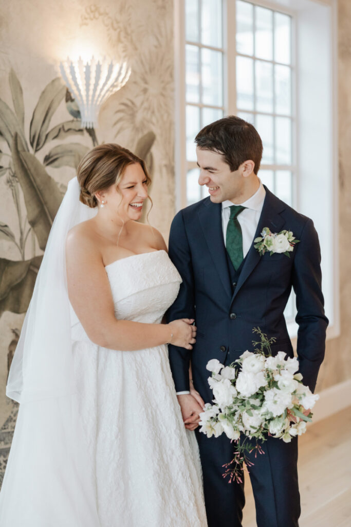 Bride and groom smiling together indoors, soft natural light portrait at Newport wedding venue